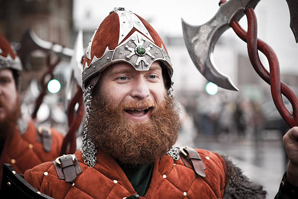 Shetland Isles, Scotland, UK - January 27, 2015: Vikings Marching on Up Helly Aa day 2015 in Lerwick in the Shetland Isles.  Also pictured are locals and tourists looking on.