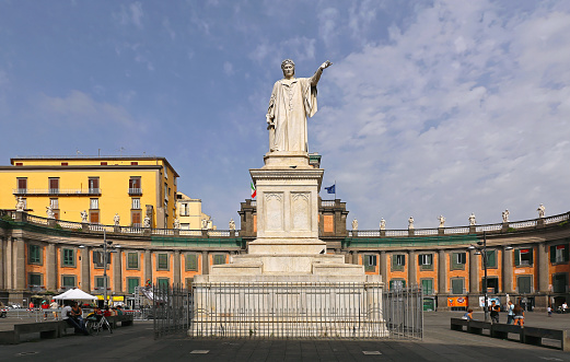 Naples, Italy - June 25, 2014: Dante Alighieri monument and Convitto Nazionale Vittorio Emanuele with people looking around in Napoli, Italy.