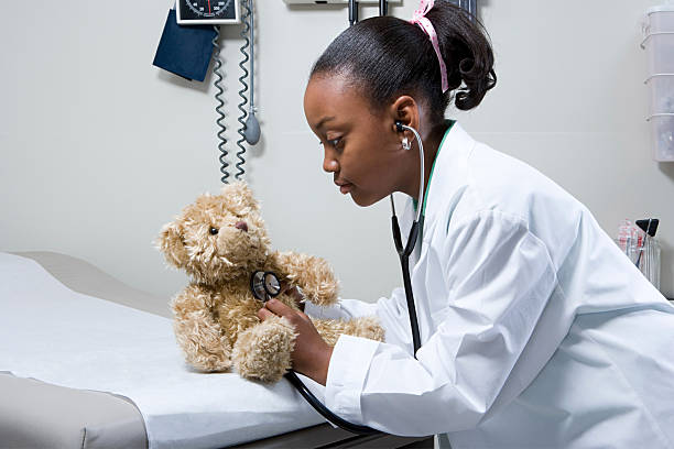 istock Girl doctor using stethoscope on teddy bear 535114863