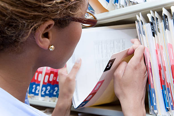 administrador olhando para a ficha médica - medical record imagens e fotografias de stock