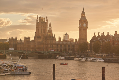London, United Kingdom - October 30, 2013: View towards big ben and the Houses of parliament. In front the River Thames and river boats a hazy day.