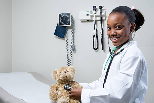 istock Girl doctor using stethoscope on teddy bear 535116621