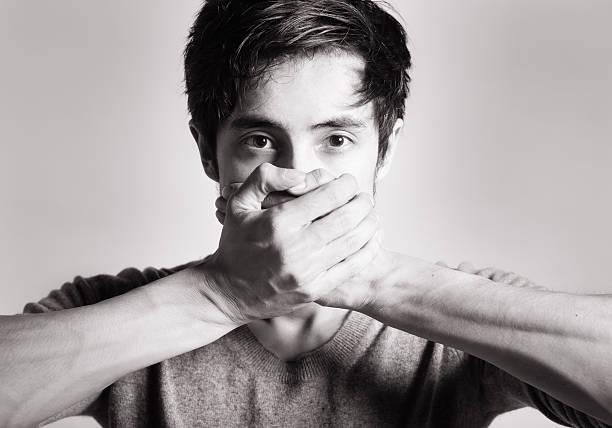 istock male covering mouth 535118783