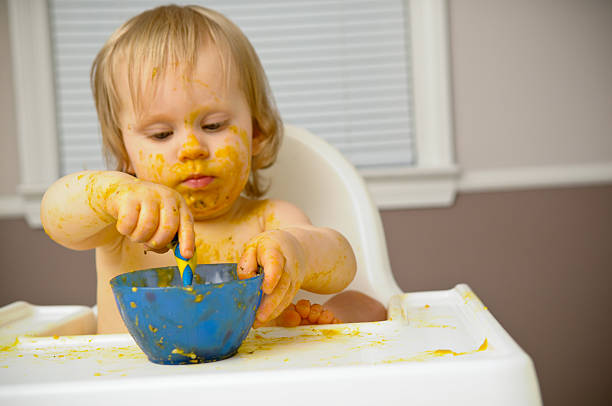 istock Baby Getting Messy While Eating Food in Highchair 535119155