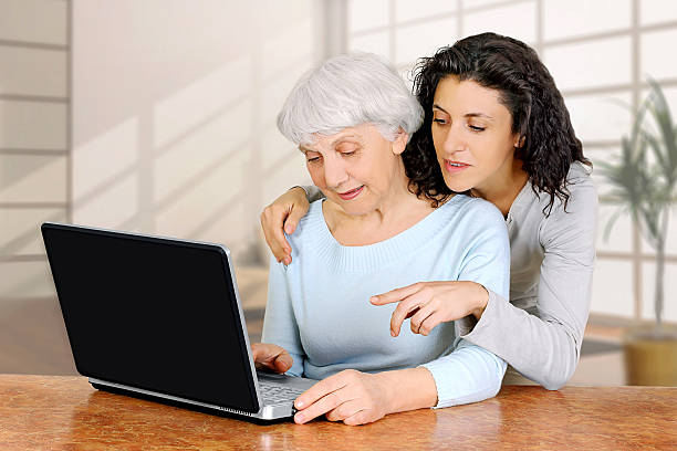 istock young  teaches elderly woman senior using laptop computer 535161493