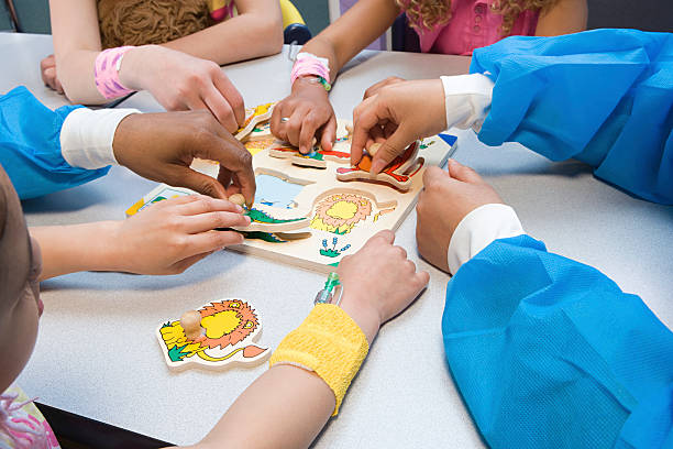 kinder spielen mit puzzle und krankenschwester spielen - xing stock-fotos und bilder