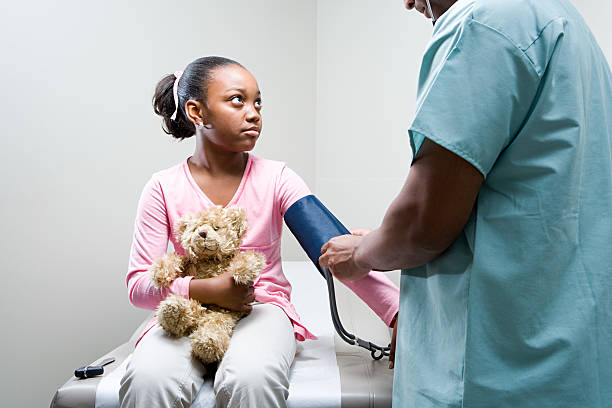girl having a check up - blodtryck orolig bildbanksfoton och bilder