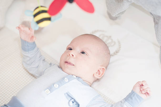 istock Charming baby playing with a toy lying on back 535165047