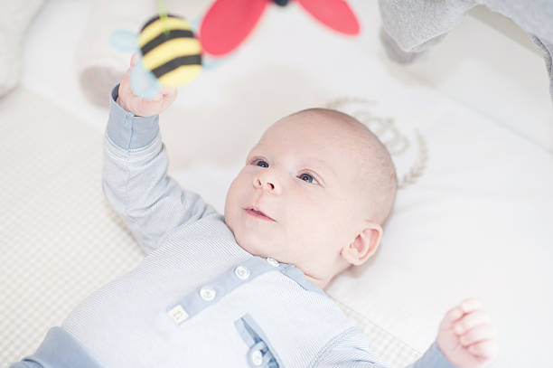 istock Lovely baby playing with a toy lying on back 535165053