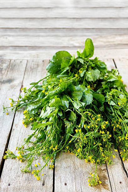 Fresh market Choy Sum or Chinese flowering cabbage on an old wooden table. This healthy green leafy vegetable is popular across the world.