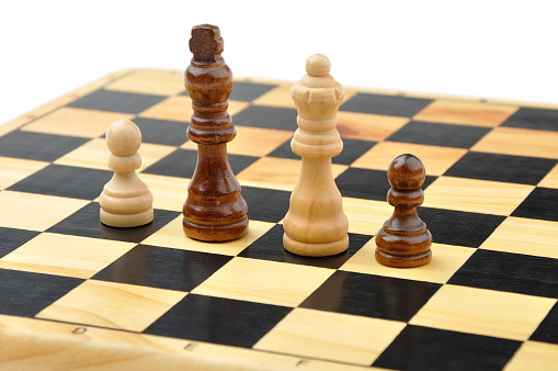 Chess figures king, queen and two pawns as concept of interracial family