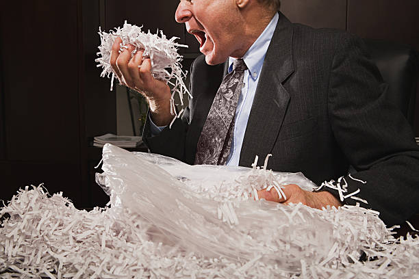 istock Mature businessman playing with paper shreddings 535166913