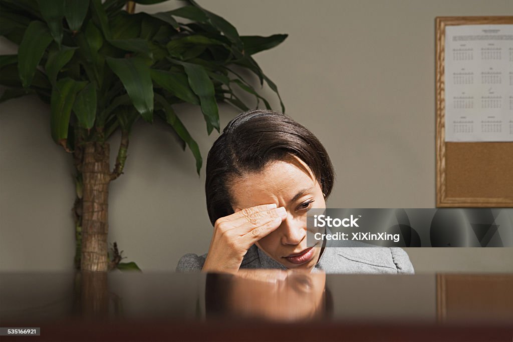 Businesswoman with her head in her hands Office Stock Photo