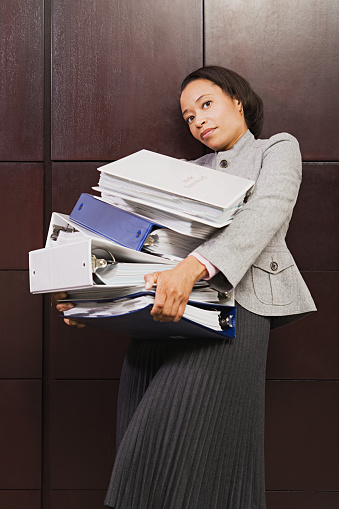 Businesswoman struggling with heavy files