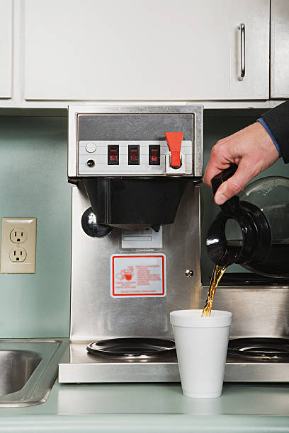 Businessman pouring a coffee Businessman pouring a coffee coffee pot stock pictures, royalty-free photos & images