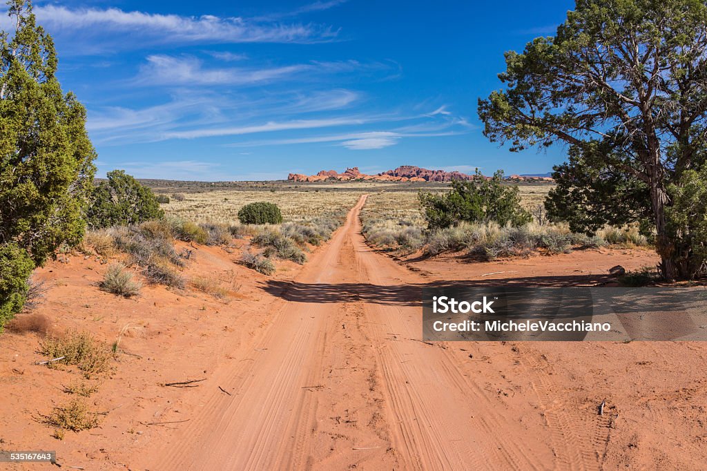 Arches National Park. Vegetation, dirt road and sandstone rocks United States. Utah. Arches National Park. Vegetation, dirt road and sandstone rocks. The Park is located about 5 miles north of Moab (Grand County), and contains the world's largest concentration of natural sandstone arches. It also contains various geological formations. 2015 Stock Photo