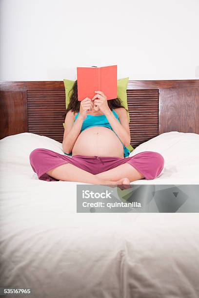Pregnant Reading Sitting In Bed Stock Photo - Download Image Now - Book, Pregnant, Reading
