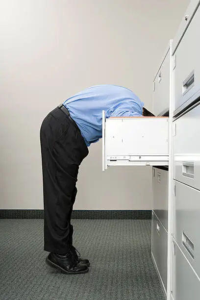 Photo of Man looking in filing cabinet