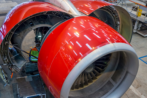 Copenhagen, Denmark: January 21, 2015: Technician at Copenhagen airport is repairing huge engine on wide body aircraft A330. Engine is opened, so technician can go inside and lit engine from inside. 