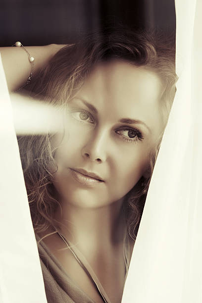 istock Sad beautiful woman looking out window 535171563
