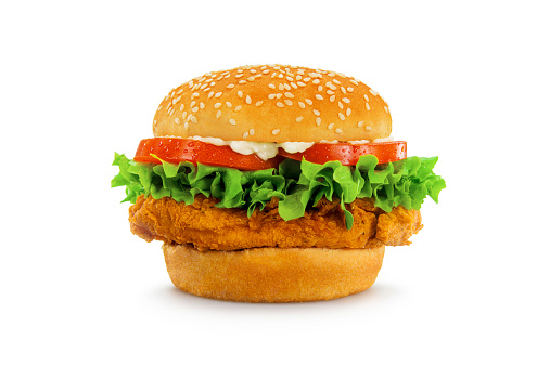 A crispy chicken sandwich, perfectly proportioned and styled, shot in an aspirational fast food advertising style and isolated on white. Sesame seed bun, visible condensation on tomatoes, lettuce, and mayo.