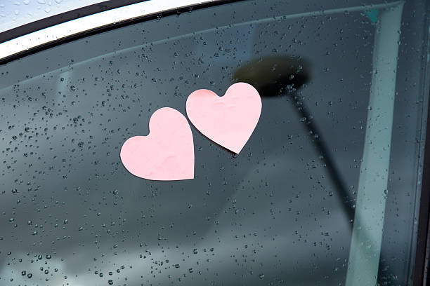 istock Two heart shaped post-it on a car window with raindrops 535191433
