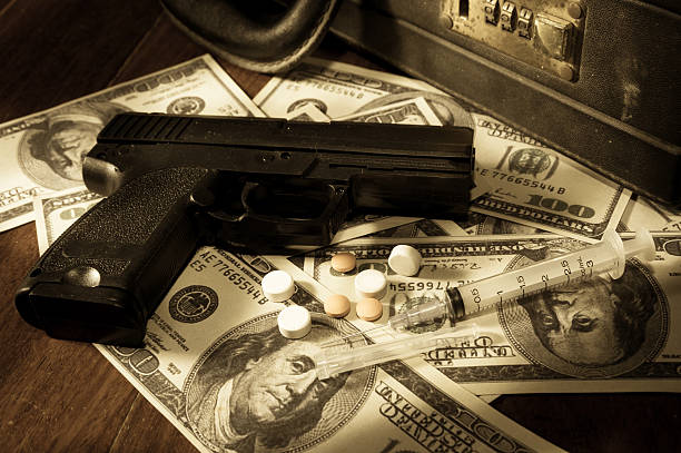 gun, spritze und pillen mit dollar-banknoten. - currency crime gun conflict stock-fotos und bilder