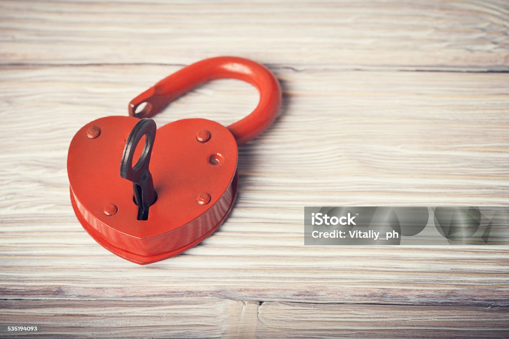 Open heart shaped lock and key over vintage wooden background Open heart shaped lock and key over light vintage wooden background 2015 Stock Photo