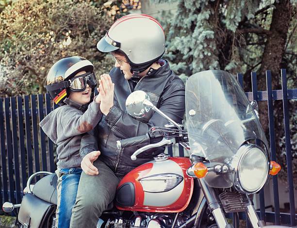 istock Dad and Son Giving a Five Riding a Motorcycle 535196603