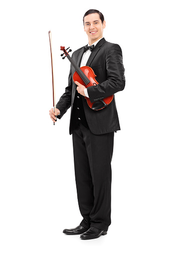 Full length portrait of a violinist holding a wand and a violin isolated on white background