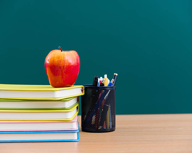 istock apple and books next to chalk board 535198165