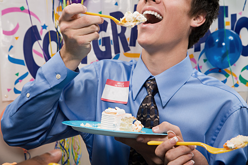 Businessman eating party cake