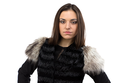 Portrait of woman in black fur waistcoat on white background
