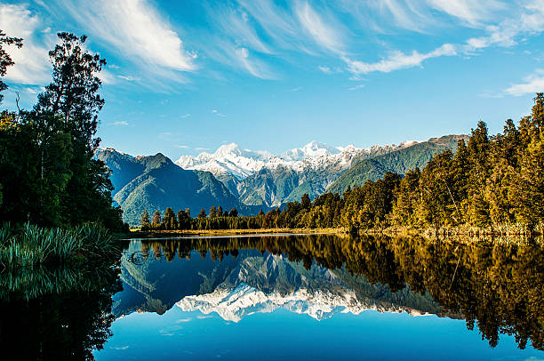 Reflections in Lake Matheson Reflections of Mount Cook and Mount Tasman in Lake Matheson, Fox Glacier New Zealand.  fox glacier photos stock pictures, royalty-free photos & images