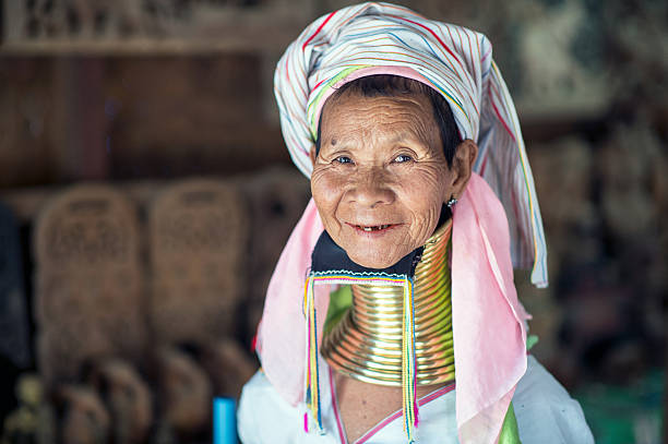 Faces of Myanmar Bagan, Myanmar - February 8, 2014: Portrait of smiling Long neck Kayan Lahwi woman with traditional headdress and brass coils around her neck. Brass coils creating long necks is a tradition of the Kayan Lahwi women. kayan neck rings stock pictures, royalty-free photos & images
