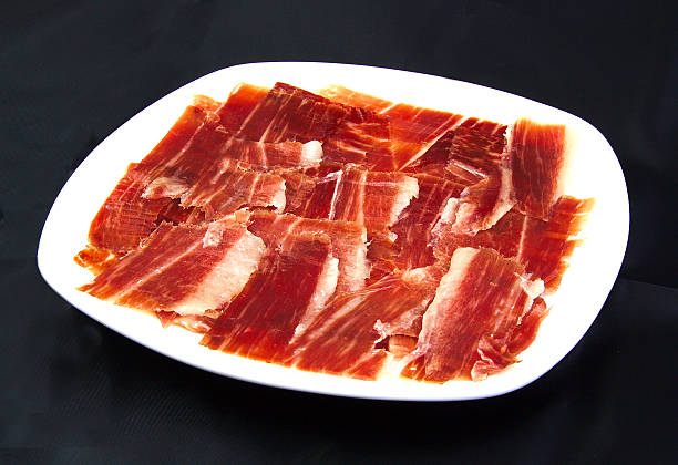 セラーノハムのスライスを、白にブラックの wackground 料理 - serrano chilli pepper meat ham spain ストックフォトと画像