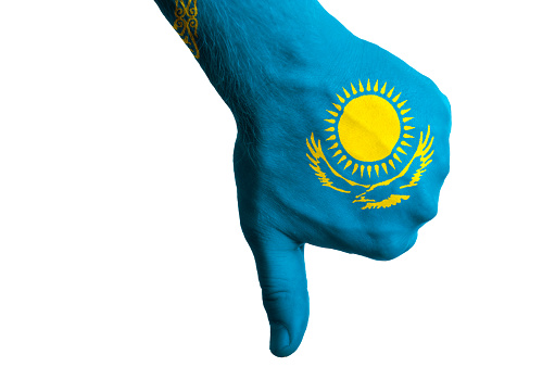 Hand with thumb down gesture in colored kazakhstan national flag as symbol of negative political, cultural, social management of country