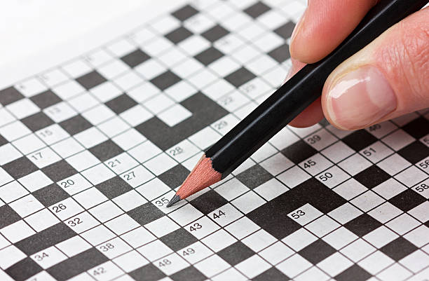 istock female hand holding a pencil and solves crossword puzzle 535228521