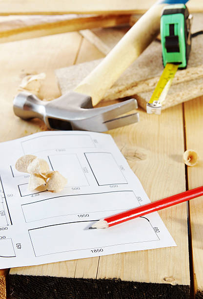 istock Hammer and a plan with pencil lie on the workbench 535228953
