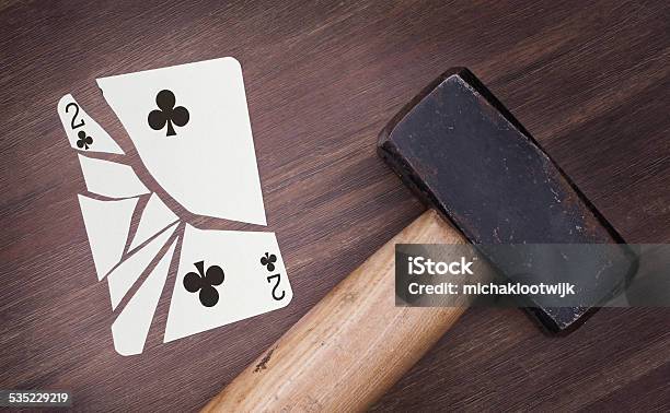 Hammer With A Broken Card Two Of Clubs Stock Photo - Download Image Now - 2015, Addiction, Breaking