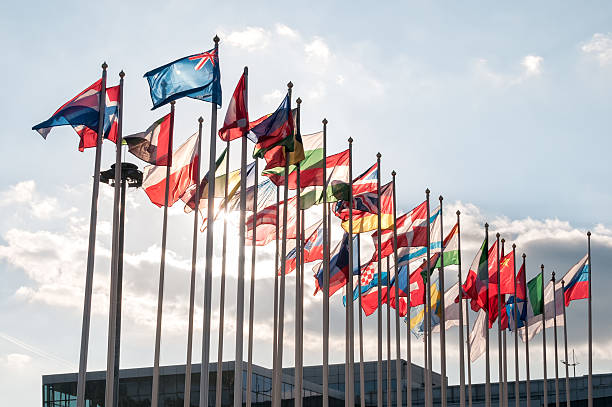 istock United Flags in backlit on blue sky background 535239019