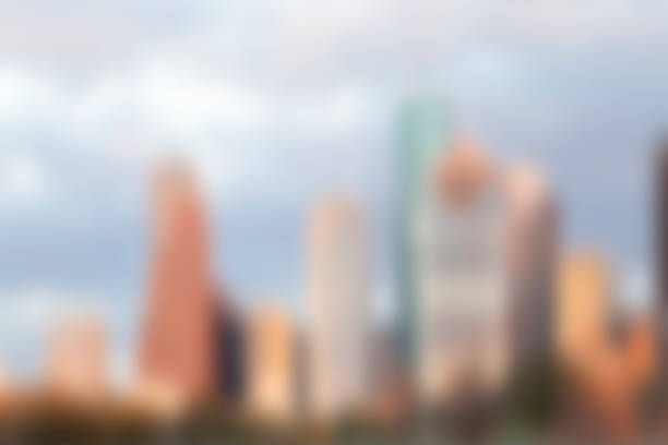 Blurred image makes a great cityscape background. Houston, Texas, USA downtown skyline.  Tall skyscrapers and glass buildings. Clouds on blue sky. No people. Sunny day.