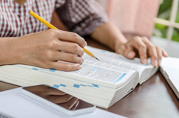 Self learning Image of woman checking a term in a dictionary dictionary stock pictures, royalty-free photos & images