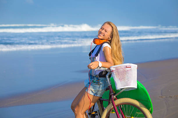 istock Young girl with surfboard and bicycle 535261807