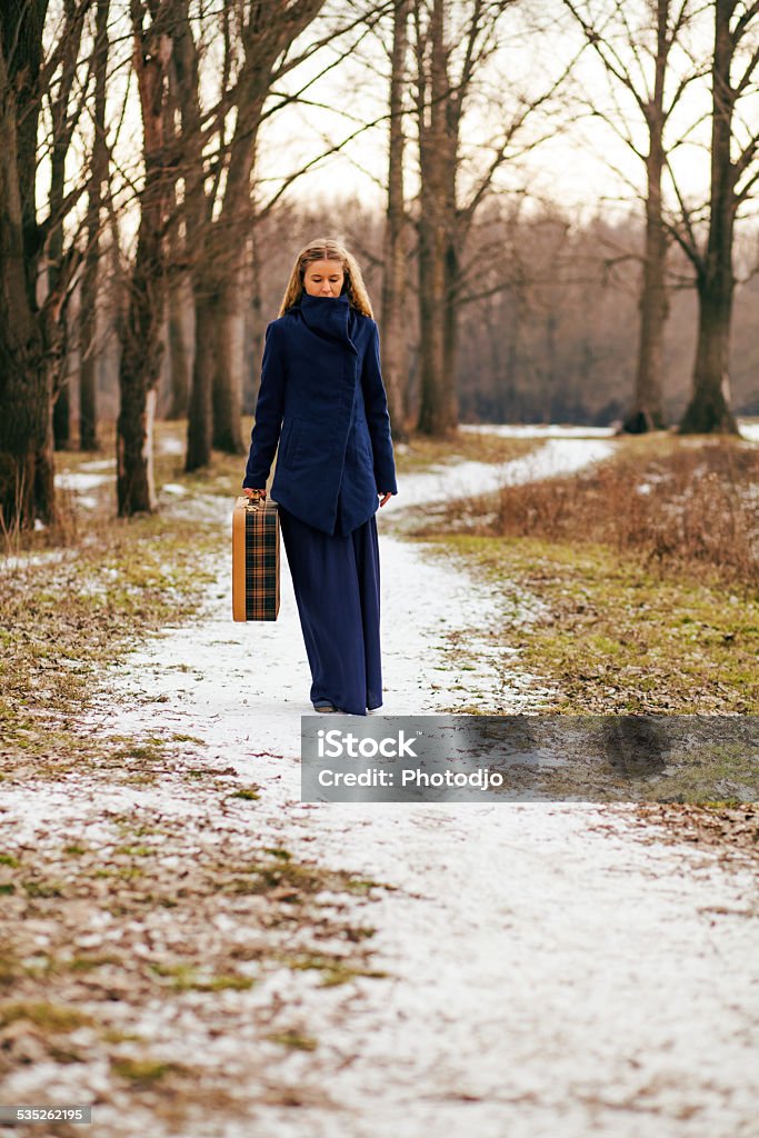 Lonely traveler Woman walking on forest path with old suitcase 2015 Stock Photo