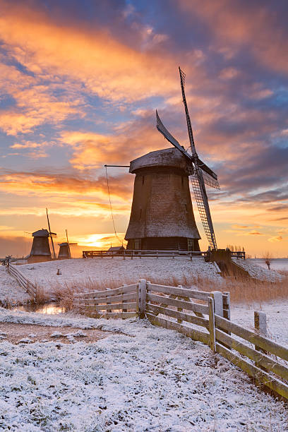 moulins à vent néerlandais traditionnels en hiver au lever du soleil - polder windmill space landscape photos et images de collection