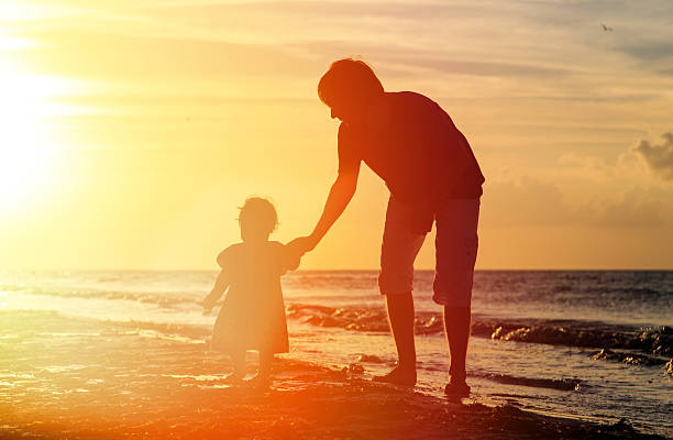 istock Father and little daughter silhouettes at sunset 535264805