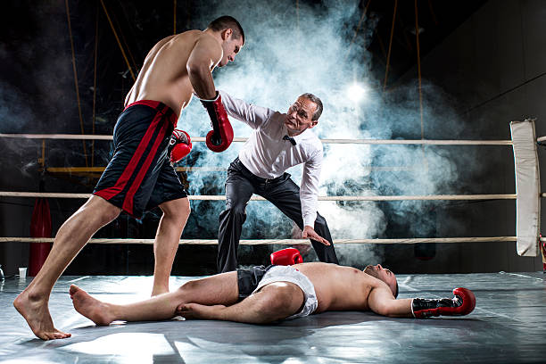 Knockout! Boxing match. One boxer has received a knockout and is lying down, while the other is standing next to him with a referee.    knockout stock pictures, royalty-free photos & images