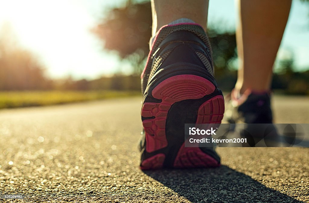 Woman running Close up of a woman running on a road. Asphalt Stock Photo