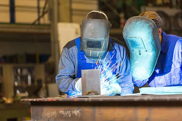 Photo of Two steel construction workers welding metal